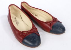 A pair of maroon Chanel ballet leather ballet flat shoes with navy toe caps, embroidered with the CC