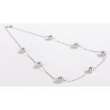 An 18 carat white gold necklace, with seven grey pearls, 6.6g, 44cm long