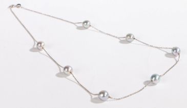 An 18 carat white gold necklace, with seven grey pearls, 6.6g, 44cm long