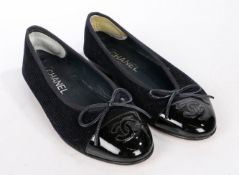 A pair of black leather Chanel ballet flat shoes. Quilted leather with black monogramed toe cap.