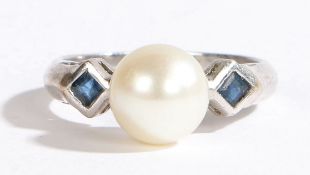 An 18 carat white gold ring, set with a central pearl flanked by two sapphires, ring size J, 4g