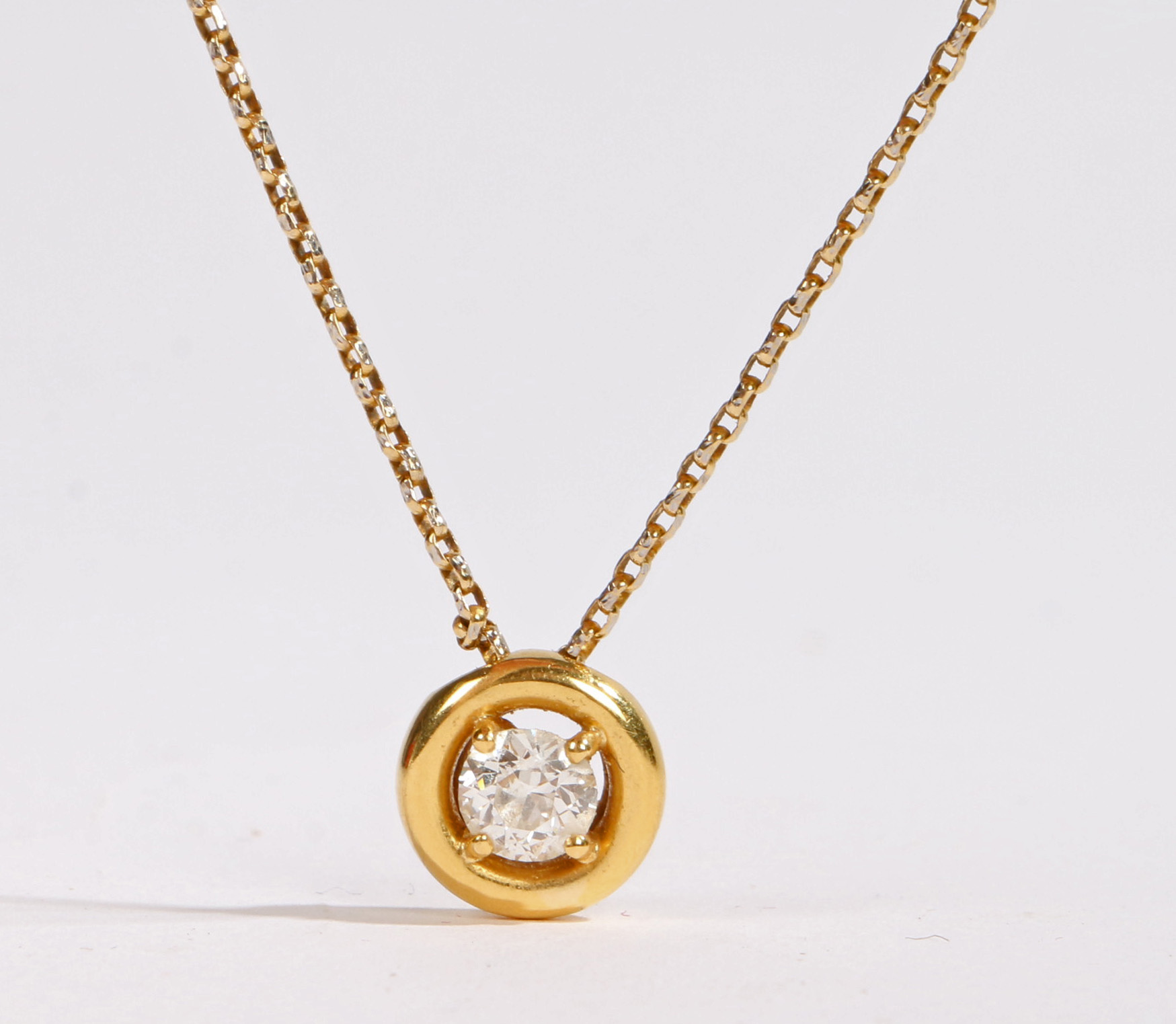 An 18 carat yellow gold and diamond pendant necklace, the pendant set with a single 0.6ct round