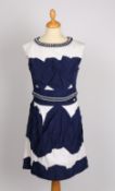 A Chanel sleeveless dress with navy and white textured panels and a chunky link belt and collar.