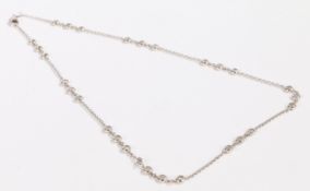 An 18 carat white gold and diamond necklace, the circular chain-link necklace with nine groups of