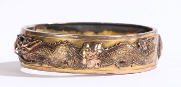 A Chinese 14 carat gold bracelet, decorated with raised depiction of a dragon and a bird chasing a