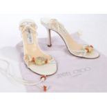 A pair of Jimmy Choo white leather strappy stiletto heels with faux amber detail. Size 36.