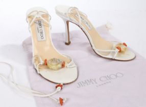 A pair of Jimmy Choo white leather strappy stiletto heels with faux amber detail. Size 36.