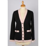 Two Chanel cardigans; a Chanel white single breasted wool cardigan with  black trim and CC logo