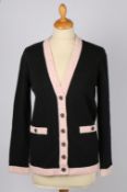 Two Chanel cardigans; a Chanel white single breasted wool cardigan with  black trim and CC logo