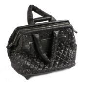 A Chanel trolley bag, with collapsible black handle, two carrying handles, black quilted exterior