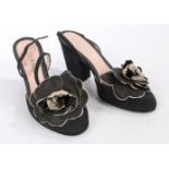 A pair of Chanel black suede open toed heels with block heel and camellia decoration to the toe.