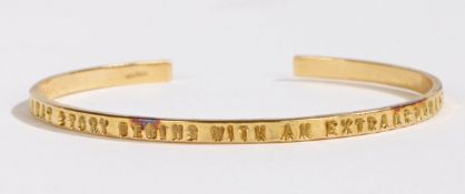 An 18 carat gold bracelet, the exterior of the band stamped "EVERY GREAT STORY BEGINS WITH AN