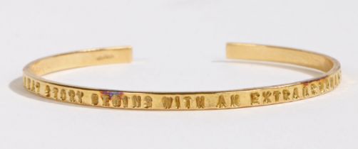 An 18 carat gold bracelet, the exterior of the band stamped "EVERY GREAT STORY BEGINS WITH AN