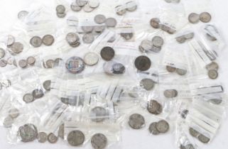 A collection of coins and tokens, to include George V and VI shillings, threepences, enamel