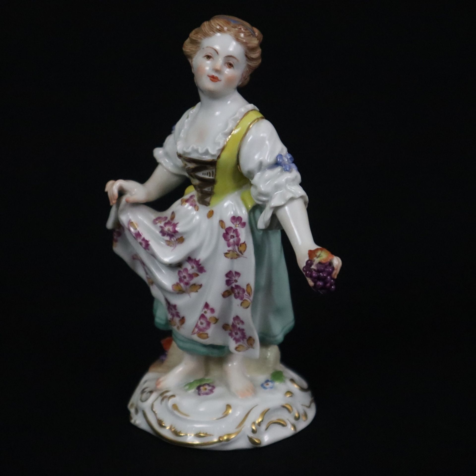 Porzellanfigur "Gärtnerin mit Trauben" - Meissen, 20. Jh., Porzellan, polychrome Bemalung, Goldstaf