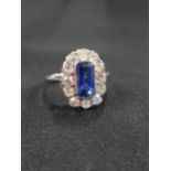 18 CARAT WHITE GOLD SAPPHIRE AND DIAMOND CLUSTER RING - TRAP CUT SAPPHIRE CENTRE STONE WITH 12