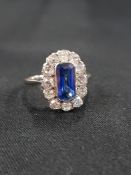 18 CARAT WHITE GOLD SAPPHIRE AND DIAMOND CLUSTER RING - TRAP CUT SAPPHIRE CENTRE STONE WITH 12