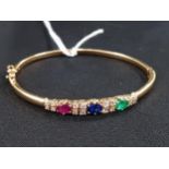 18 CARAT GOLD BANGLE WITH SAPPHIRE, EMERALD, RUBY & CIRCA HALF CARAT OF DIAMONDS