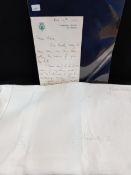 A handwritten letter by Queen Elizabeth II with associated white linen tea cloth. A handwritten