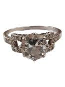 PLATINUM AND DIAMOND RING WITH MAIN DIAMOND SOLITAIRE AND DIAMONDS TO EACH SHOULDER SETTING. CIRCA 1