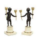 A pair of 19th century French patinated and gilt bronze and white marble figural twin-light cand...