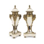 A pair of late 19th century French gilt bronze and white marble garniture urns in the Louis XIV ...