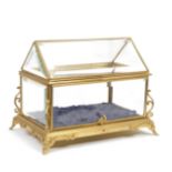 A late 19th/early 20th century French gilt metal and bevelled glass table top bijouterie cabinet...