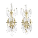A pair of gilt bronze and cut and moulded glass twin-light wall appliques en suite to the previo...