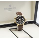 Patek Philippe. A fine 18K rose gold automatic calendar wristwatch with dual time indication Ca...
