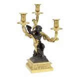 A French gilt and painted bronze figural three light candelabrum probablythe figure possibly af...