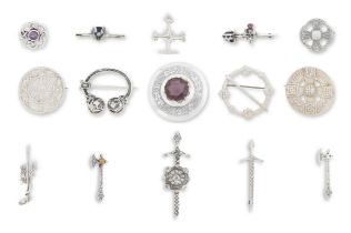 A collection of silver brooches