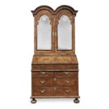 A Queen Anne walnut and featherbanded 'double-domed' bureau cabinet