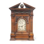 A large late 19th century carved and stained walnut chiming bracket clock the dial signed Huxta...