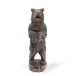 An early 20th century Black Forest carved and stained linden wood model of a standing bear