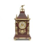 A late 19th century French gilt brass mounted and stained wood table clock with unique winding s...