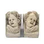 A pair of late 19th century buff glazed terracotta mask head keystones of putti by Lipscombe & C...