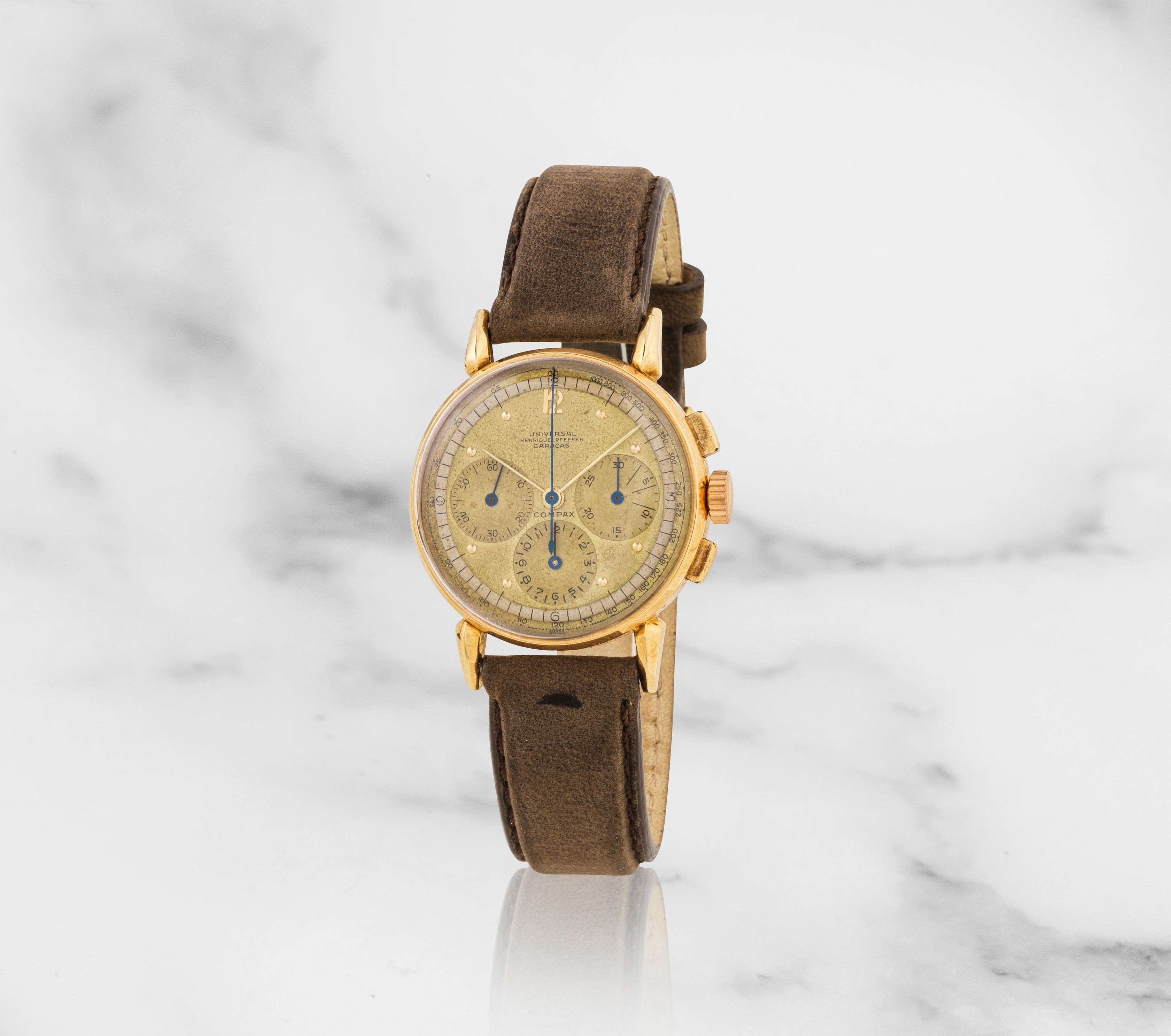 Universal Gen&#232;ve. An 18K gold manual wind chronograph wristwatch retailed by Henrique Pfeff...