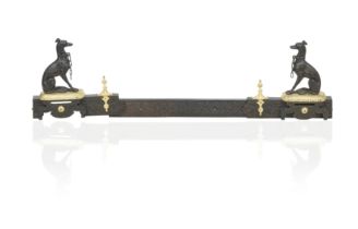 A late 19th century cast iron and gilt metal adjustable fender with a seated Greyhound terminals