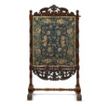 An 18th century crewelwork panel mounted within an adjustable Dutch 19th century walnut fire screen