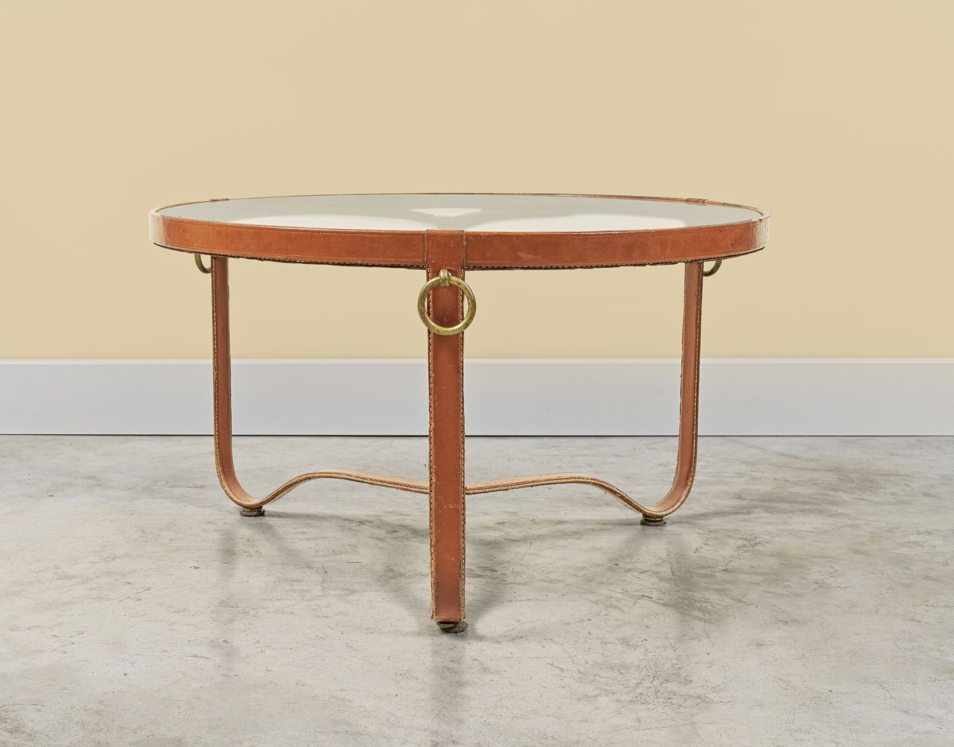 JACQUES ADNET (1901-1984) Table basse tripodeCr&#233;ation circa 1949Cuir, bronze, laiton et ver...