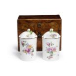 A pair of Mennecy tobacco jars and lids, circa 1755, in a fitted Louis XV marquetry travelling case