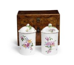 A pair of Mennecy tobacco jars and lids, circa 1755, in a fitted Louis XV marquetry travelling case