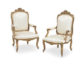 A pair of French late 19th/early 20th century giltwood fauteuils a la Reine in the Regence style...