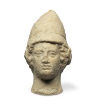 A Greek terracotta head of a warrior wearing a pilos helmet