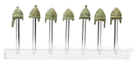 A group of seven Greek bronze miniature votive pilos helmets 7