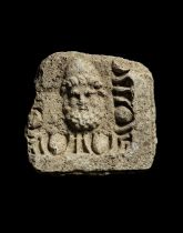 A Roman limestone relief of a male head, probably Hephaestus or Odysseus