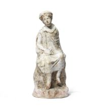 A Tanagra terracotta youth seated on a rock