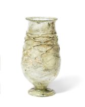 A large Gallo-Roman pale green glass footed goblet with applied net trail
