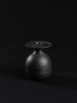 HANS COPER (1920-1981) Bottle with disc top, circa 1965Stoneware, black glaze over a textured an...