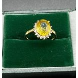 Ladies 10ct yellow gold ring set with a large yellow stone off set by white stones. [Ring size N] [